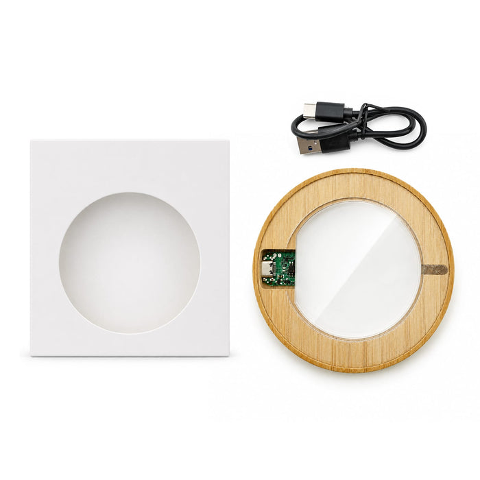 Crescent Illuminating Wireless Charger - A circular bamboo wireless charger in a white square box, with a USB charging cable included.