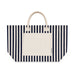 Hampton Tote Bag by The Line Edit. - A striped tote bag featuring navy blue and cream colours with two handles and a front pocket. It has a logo.