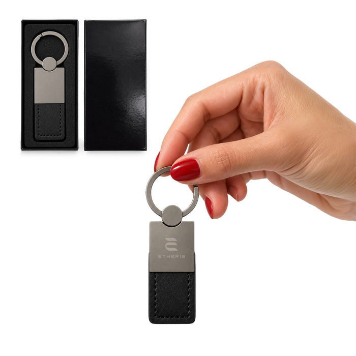 Mario Keytag - A hand holding a silver and black keytag, displayed in a black box. The keytag features a ring and a leather-like base.