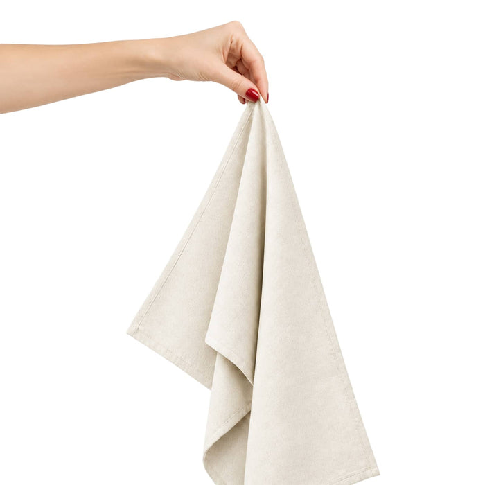 Haven Large Cotton Tea Towel - A hand holds a light beige cotton tea towel, showcasing its soft fabric and folded design.