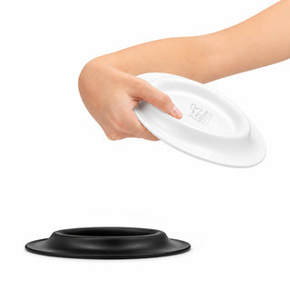 Sip n Fly Pet Bowl - A hand holds a white pet bowl above a black base, showcasing a two-piece design for easy assembly and use.