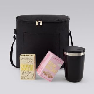 The Pause Pack - A black insulated bag with a drink tumbler and two boxes of chocolate and marshmallow products.