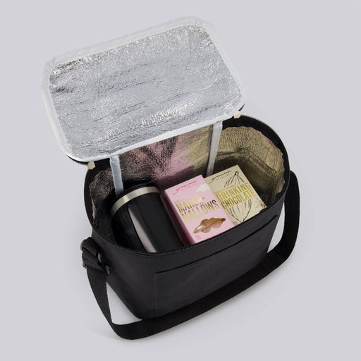 The Pause Pack - A black insulated bag containing a drink bottle, snacks, and a box of chocolates, with a silver liner.