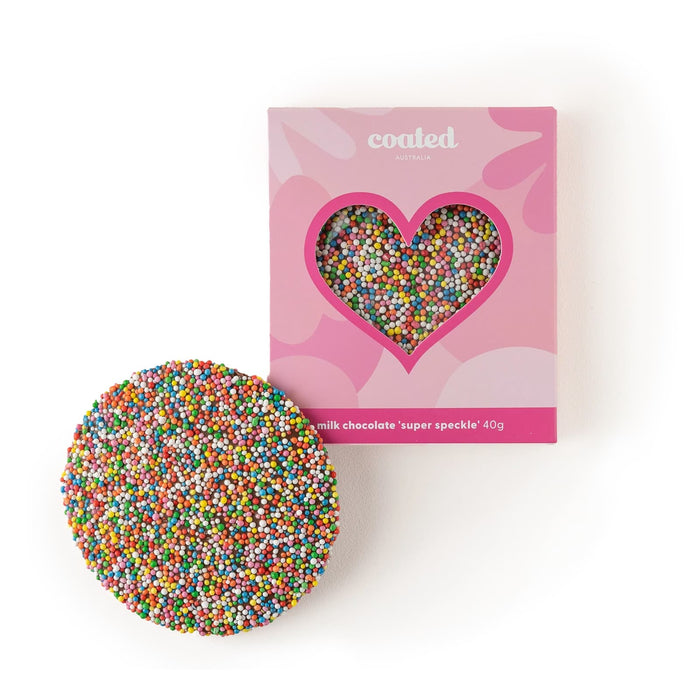 The Generous Host - A round cookie covered in colourful milk chocolate sprinkles next to a pink box with a heart-shaped window.