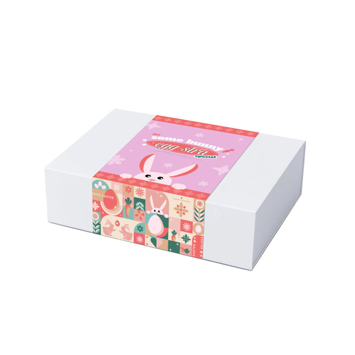 The Sweet Setup - A gift box with a pastel pink design featuring bunny illustrations and decorative patterns, secured with a printed band.