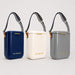 Pavilion Cooler by The Line Edit. - A set of three Pavilion Coolers in navy, cream, and grey, each with a strap and a logo.