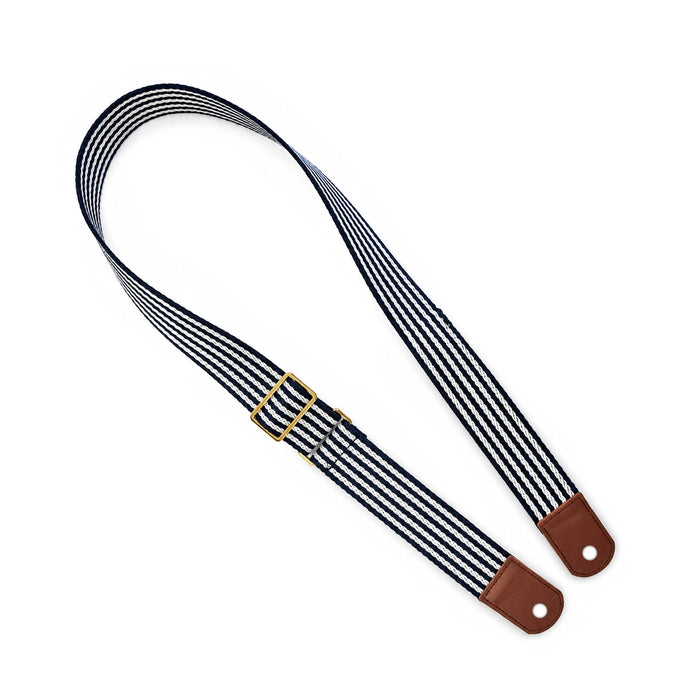 Pavilion Cooler by The Line Edit. - A striped shoulder strap in navy and white with brown leather ends and a gold buckle. It has a stylish design.