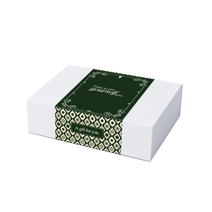 The Sparkling Moment - A white hamper box with a green decorative band featuring intricate patterns and a gift message.