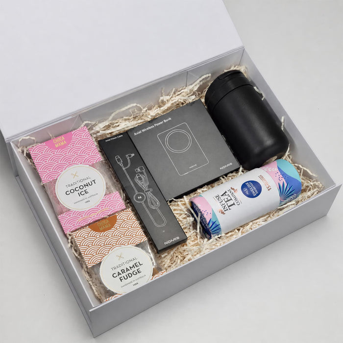 The Modern Essential Gift Set - A gift box containing a black drink bottle, snacks, and a card set, all set on shredded paper packaging.