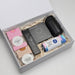 The Modern Essential Gift Set - A gift box containing a black drink bottle, snacks, and a card set, all set on shredded paper packaging.