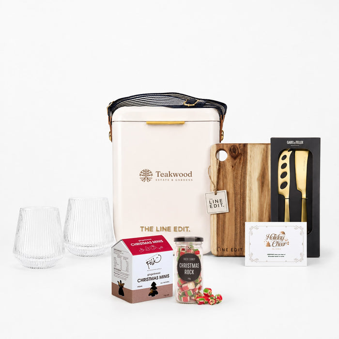 The Festive Edit Gift Set - A festive gift set featuring two glass tumblers, a wine cooler, a wooden board, a knife, and Christmas-themed treats.