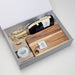 The Sparkling Moment - A gift box containing a bottle of sparkling wine, a wooden chopping board, and caramel fudge. The box has a minimalist design.