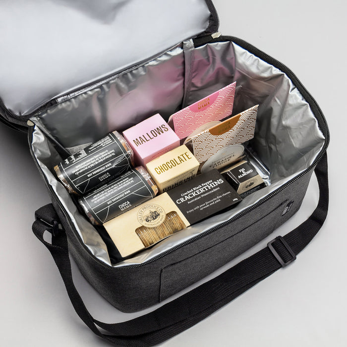 The Good Things - A grey insulated bag containing various snacks, including chocolates, crackers, and marshmallows.