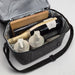 The Coastal Edit - A grey cooler bag containing bottles of wine, skincare products, and a wooden board, all neatly organised inside.