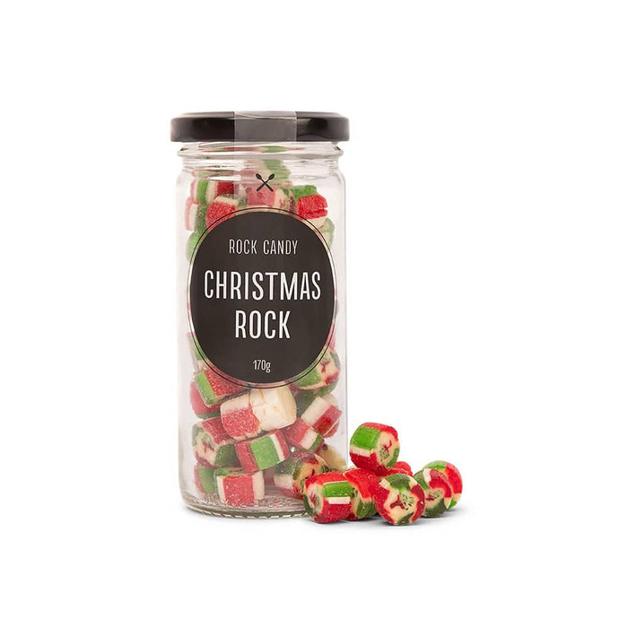 The Refined Graze: Christmas Edition - A glass jar filled with red, green, and white rock candy pieces, with some scattered outside. The jar has a black lid.