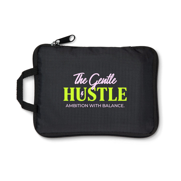 The Hustle Pack - A black zippered pouch with a handle, featuring colourful text and a logo.
