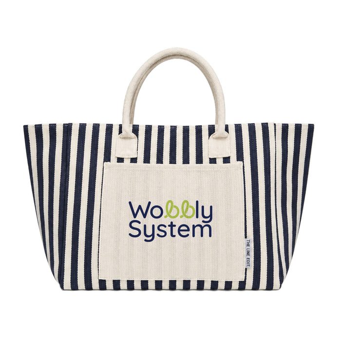 The Good Stuff Pack - A striped tote bag in navy and cream featuring a pocket with a logo. The bag has sturdy handles for carrying.