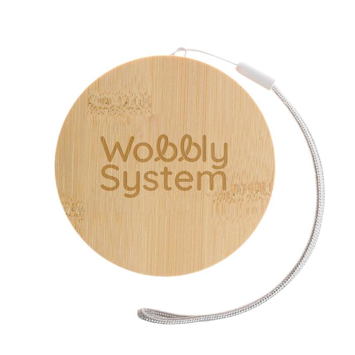 The Good Stuff Pack - A round bamboo coaster with a textured surface and a silver loop attached, featuring the words "Wobbly System".