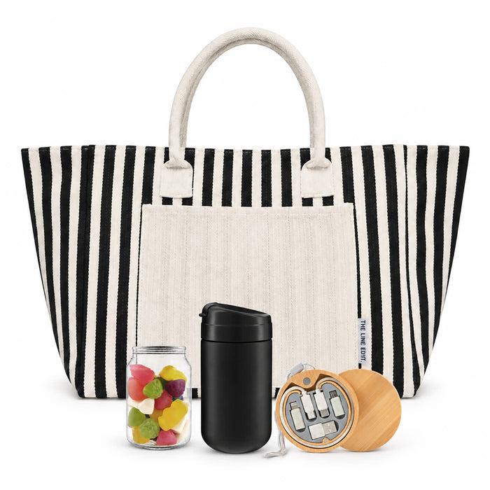 The Good Stuff Pack - A striped tote bag with a white pocket, containing a black drink bottle, a jar of colourful sweets, and a wooden keychain.