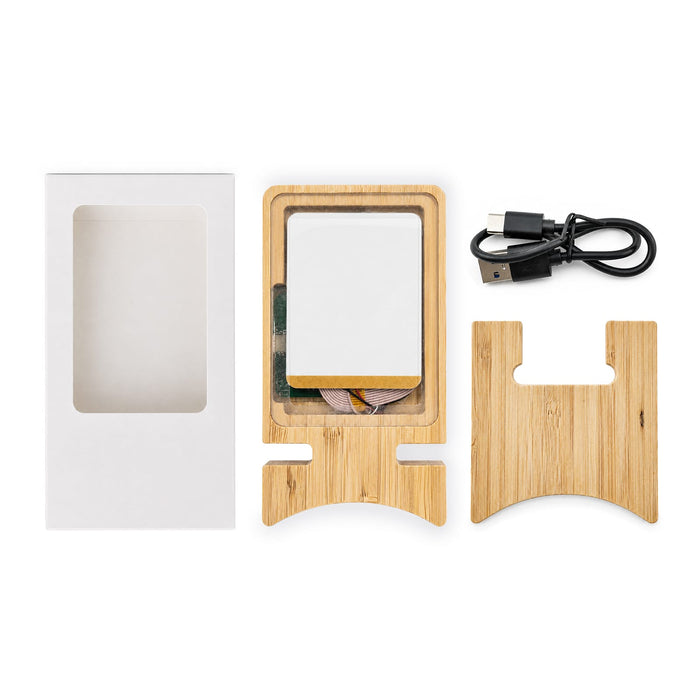 Oscar Illuminating Charging Stand - A bamboo charging stand with a white charging pad, USB cable, and packaging box, all neatly arranged.