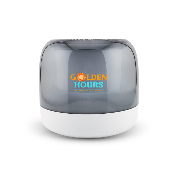 Dazzle RGB Speaker - A compact speaker featuring a grey translucent cover and a white base, with branding on the front.