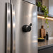 Empire Maglock Ph Stand Speaker - A compact black speaker magnetically attached to a stainless steel fridge in a modern kitchen setting.