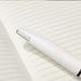 Axel Matte - A white pen rests on a lined notebook page, featuring a sleek design and minimalistic style.