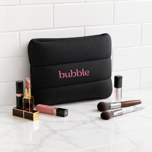 Bubble Neoprene Cosmetic Bag - A black neoprene cosmetic bag with pink branding, surrounded by various lip products and makeup brushes.