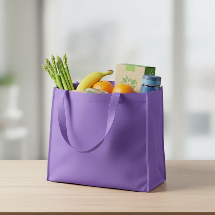 Medium Non Woven Tote - A purple non-woven tote filled with bananas, oranges, asparagus, and a drink bottle. It has two handles.