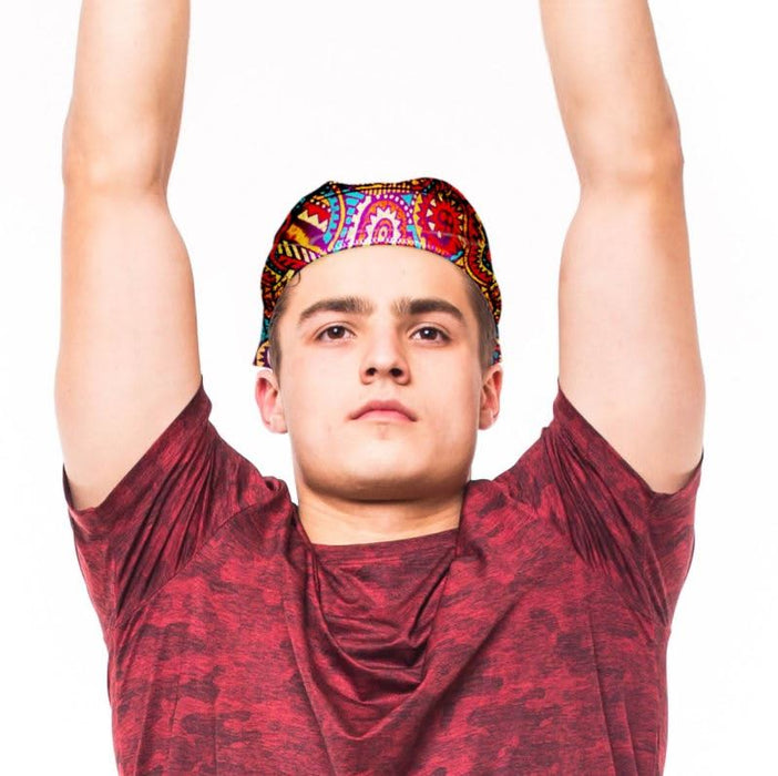 Very Kool Cooling Bandana - A person wearing a brightly patterned bandana, raising their arms, dressed in a red shirt. The bandana features vibrant colours.