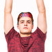 Very Kool Cooling Bandana - A person wearing a brightly patterned bandana, raising their arms, dressed in a red shirt. The bandana features vibrant colours.