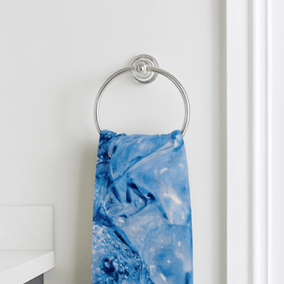 Hand Towel - A blue marble-patterned hand towel hanging on a silver towel ring against a white wall.