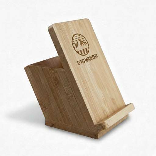 Bamboo Mobile Stand and Pen Holder - A bamboo mobile stand and pen holder with an angled design and a logo on the front.