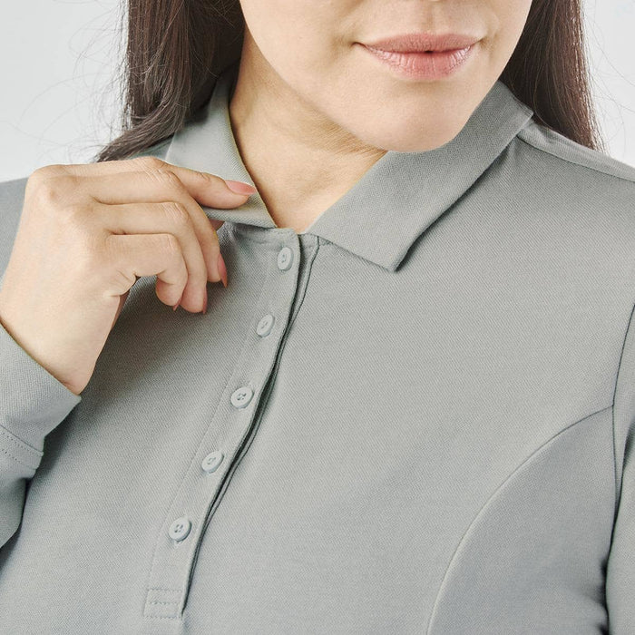 Women's Nevada L/S Micro Pique Polo - A close-up of a woman adjusting the collar of a grey long-sleeve polo shirt with buttons and a logo.