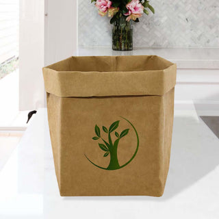 Sewo Kraft Paper Storage Bag – Extra Large - A large brown kraft paper storage bag featuring a green logo of a tree and leaves, placed on a table.
