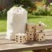 Wooden Yard Dice set - A wooden yard dice set with five large dice and a drawstring canvas bag, set on a wooden table outdoors.