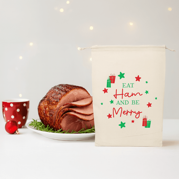 Christmas Ham Bag - A cream-coloured bag with festive designs next to a glazed ham on a platter and a red polka dot cup.