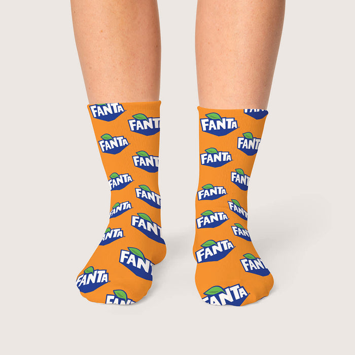 Magic Dress Socks - Bright orange socks with repeated Fanta branding, featuring a logo and green leaf design.