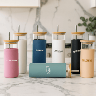 Sunrise Smoothie 500mL Tumbler - A collection of colourful plastic tumblers with bamboo lids and straws in various shades, featuring different logos.