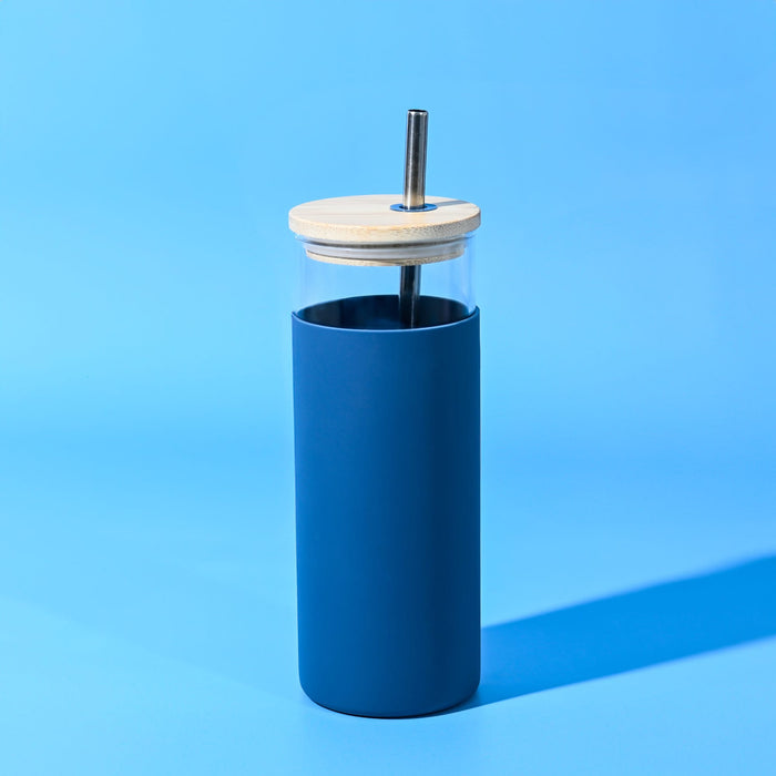 Sunrise Smoothie 500mL Tumbler - A drink bottle with a blue silicone exterior, wooden lid, and metal straw on a blue background.