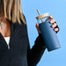 Sunrise Smoothie 500mL Tumbler - A drink bottle with a glass body and blue silicone sleeve, featuring a bamboo lid and stainless steel straw.