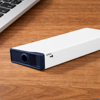 Screwdriver Tape Measure - A white screwdriver tape measure with a dark blue end, resting on a wooden surface near a laptop.