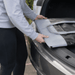 Premium 17L Foldable Cooler - A person placing a grey and black premium foldable cooler into a car boot, showcasing its compact design.