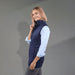 Women's Telluride Lightweight Packable Insulated Puffer Vest - A woman wearing a navy lightweight packable insulated puffer vest, paired with a light blue shirt and grey pants.