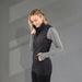 Women's Telluride Lightweight Packable Insulated Puffer Vest - A woman wearing a black lightweight packable insulated puffer vest over a grey long-sleeve top, with hands in pockets.