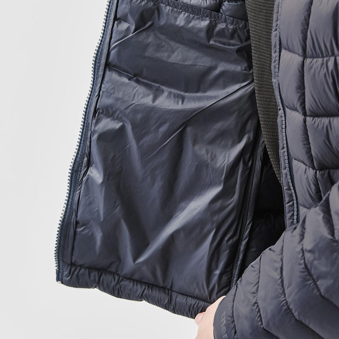 Women's Tundra Thermal Jacket - A navy blue women's puffer jacket with an unzipped interior pocket and quilted design. Features a logo on the sleeve.