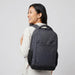 Tirano Laptop Backpack - A grey and black laptop backpack is shown worn on the back of a smiling person, featuring a logo.