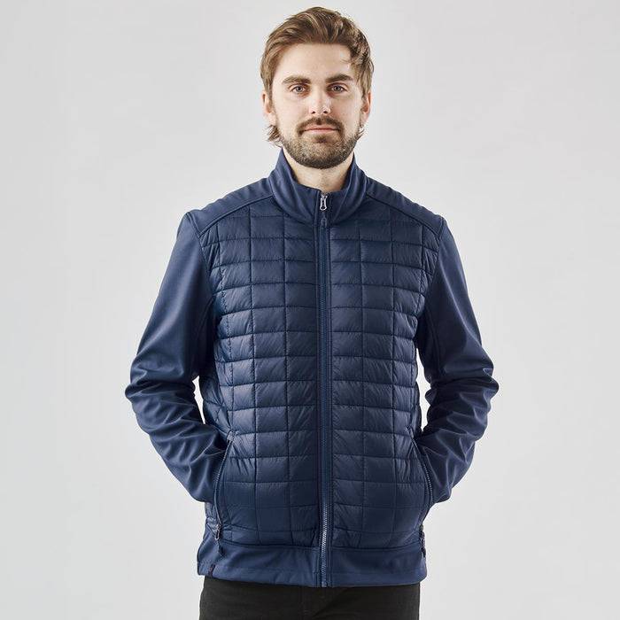 Men's Appalachian Thermal Softshell Jacket - A man wearing a navy thermal softshell jacket with a quilted front, featuring a zip and side pockets.