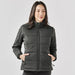 Women's Sierra Thermal Jacket - A women's puffer jacket in dark grey with a zip front, featuring side pockets and a high collar, with branding.