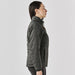 Women's Sierra Thermal Jacket - A women's puffer jacket in dark grey featured from the side, showcasing its thermal design and fitted silhouette.